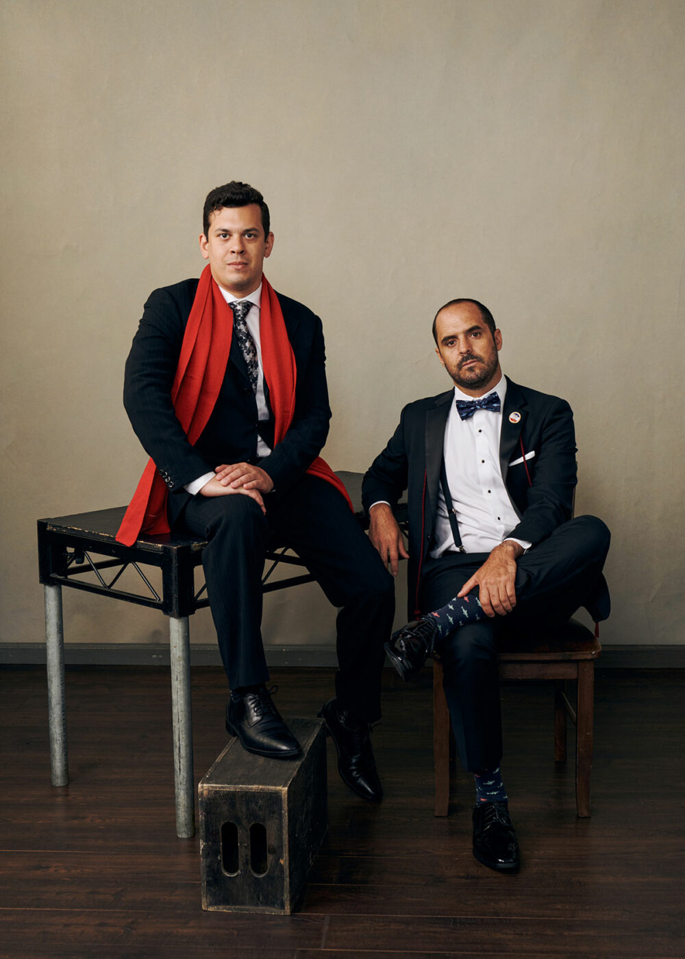 two men posing with elegant suits in a studio