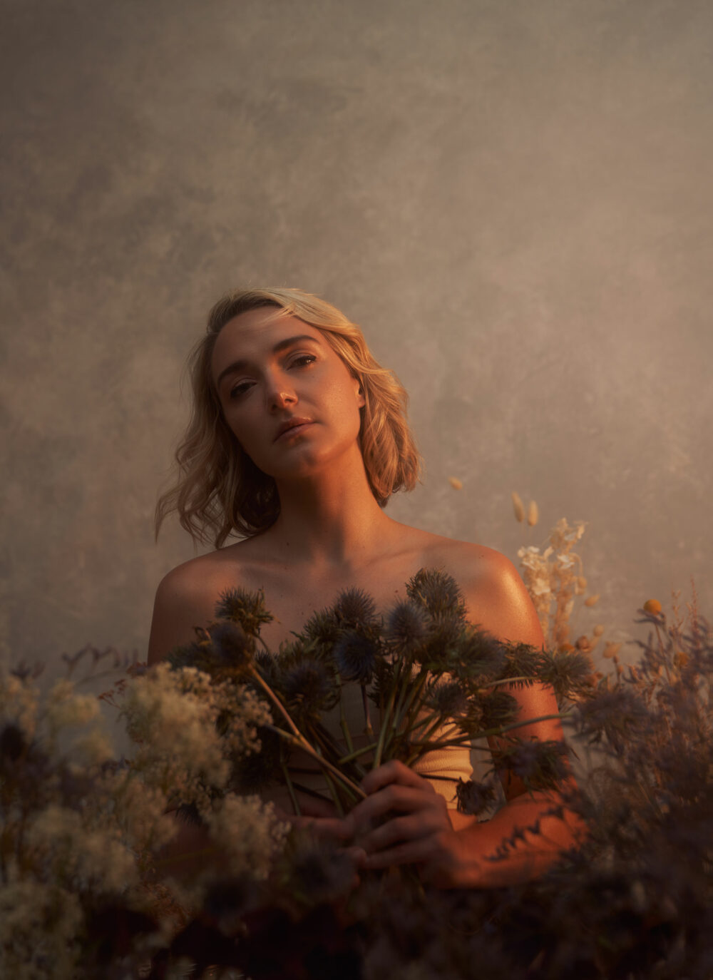 Female model with dried flowers in a warm light